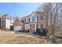 Beautiful two-story brick home with a manicured front lawn, two car garage and mature trees at 1110 Croftmoore Lndg, Suwanee, GA 30024