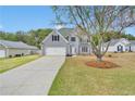 Charming two-story home with gray siding, attached garage, and well-manicured front lawn at 2061 Emerald Dr, Loganville, GA 30052