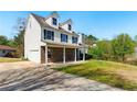 Exterior of home with wide driveway, stone facade, and covered porch at 3267 Forrest Bluff Way, Lithonia, GA 30038