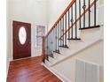 Beautiful foyer with hardwood floors and a staircase featuring black metal spindles and a wood banister at 7902 West Shore Cir, Riverdale, GA 30296