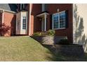 Landscaped front yard featuring lush green lawn and decorative stone wall with flowerbed at 2875 Factor Walk Blvd, Suwanee, GA 30024