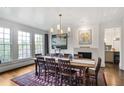 Spacious dining room with ample windows, hardwood floors, stylish lighting, and fireplace at 219 Little John Ne Trl, Atlanta, GA 30309