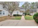 A quaint home with neat landscaping, featuring healthy grass and a blossoming tree at 6502 Wellington Chase Ct, Lithonia, GA 30058