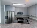 Modern kitchen featuring stainless steel appliances, gray cabinetry, granite counters, and stylish tile backsplash at 3338 Peachtree Ne Rd # 2701, Atlanta, GA 30326