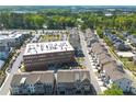 Aerial view of neighborhood featuring townhomes and commercial buildings with a green park area at 6023 Skellig St, Norcross, GA 30071