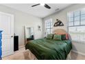 Cozy bedroom featuring natural light, a comfortable bed with stylish decor, and a ceiling fan at 6023 Skellig St, Norcross, GA 30071