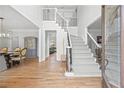 Bright foyer with hardwood floors, staircase with iron spindles, and view to the dining room at 840 Stonehaven Ln, Alpharetta, GA 30005