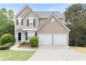 Attractive home with a two-car garage, manicured lawn, and welcoming front door at 7040 Magnolia Park Ln, Norcross, GA 30093