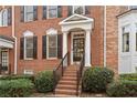 Close-up of a brick front entrance with well-manicured bushes and stairs leading to the front door at 2620 Milford Ln, Alpharetta, GA 30009