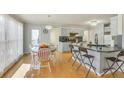 Bright kitchen featuring wood floors, bar seating, and modern lighting at 3075 Superior Dr, Dacula, GA 30019