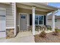 A welcoming front porch with chairs, stone accents, and a gray door at 804 Trestle Creek Ct, Temple, GA 30179