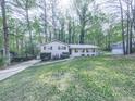 Inviting home with a lush front lawn and mature trees offering shade and curb appeal at 1090 Tanglewood Trl, Woodstock, GA 30189