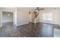 Open-concept living area featuring hardwood flooring, staircase, and neutral paint at 241 Rockingham Dr, Loganville, GA 30052