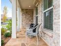 Inviting front porch featuring stone floors, seating, and elegant columns at 437 Great Pine Way, Woodstock, GA 30188