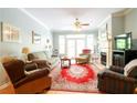 Cozy living room featuring a fireplace, ceiling fan, and natural light from a large window at 225 E Ponce De Leon Ave # 317, Decatur, GA 30030