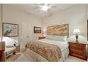 Bedroom with neutral walls, ceiling fan, a bed with decorative bedding, and artwork over a light wood headboard at 3300 Windy Ridge Se Pkwy # 612, Atlanta, GA 30339
