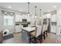 Bright kitchen featuring white cabinets, stainless steel appliances, an island with seating, and modern pendant lighting at 3628 Silvery Way, Powder Springs, GA 30127