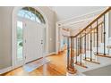 Welcoming foyer with hardwood floors, staircase with rod iron balusters, and views into the formal dining room at 940 Magnolia Blossom Ct, Alpharetta, GA 30005