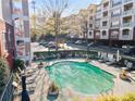 Community pool surrounded by lounge chairs and mature landscaping near a condo building at 4333 Dunwoody Park # 1211, Atlanta, GA 30338