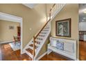 Bright foyer features hardwood floors, staircase with white risers, and a decorative bench at 735 Ambur Cove Way Nw, Lawrenceville, GA 30043