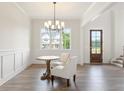 Well-lit dining room with wood floors, a chandelier, a round table, and large windows at 3315 Hillshire Dr, Cumming, GA 30028