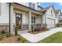 Elegant home entrance featuring a charming front porch with brick accents and a wooden front door at 3315 Hillshire Dr, Cumming, GA 30028