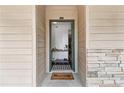 Charming front entrance featuring stone accent wall and key-shaped doormat with a view into the home's interior at 113 Brittany Ct, Duluth, GA 30096
