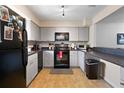 Functional kitchen features neutral cabinets, black appliances, and tiled floors at 113 Brittany Ct, Duluth, GA 30096