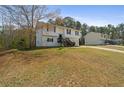 Split-level home with white siding, complemented by a spacious lawn and surrounding trees at 209 Emma Gilley Dr, Carrollton, GA 30116