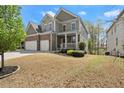 Charming two-story home featuring a stone facade, two-car garage, and a welcoming front porch at 5925 Pine Bluff Dr, Cumming, GA 30040