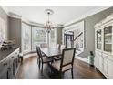 Elegant dining room featuring a chandelier, dark hardwood floors, and bay windows at 2405 Castlemaine Ct, Duluth, GA 30097
