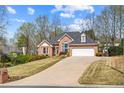 Charming brick house with an attached garage and a long driveway at 4840 Brent Knoll Ln, Suwanee, GA 30024