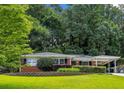 Charming brick home with well-maintained landscaping and a convenient carport, nestled among mature trees at 1323 Christmas Ne Ln, Atlanta, GA 30329