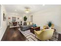 Cozy living room featuring hardwood floors, a modern sofa, comfortable armchairs, and a stylish rug at 2903 Akron Street, East Point, GA 30344