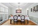 Formal dining room featuring elegant trim, a tray ceiling, and hardwood floors at 4103 Devon Wood Ne Dr, Marietta, GA 30066