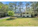 Charming two-story home with a brick facade, landscaped front yard, and driveway with carport at 539 Collingwood Dr, Decatur, GA 30032