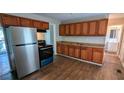 Functional kitchen with wood cabinets and modern stainless steel refrigerator at 1076 Fairburn Nw Rd, Atlanta, GA 30331