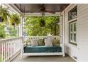 Relaxing front porch with swing, ceiling fan, and decorative pillows with green leafy tree view at 290 Georgia Se Ave, Atlanta, GA 30312