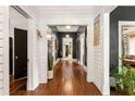 Long hallway featuring hardwood floors, white wainscoting, dark doors, and unique decor at 290 Georgia Se Ave, Atlanta, GA 30312