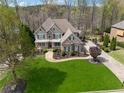An aerial view of a well-manicured property showcasing the home's architectural design and surrounding landscape at 3275 Aldrich Dr, Cumming, GA 30040