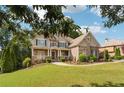 Charming two-story home with a combination of stone and brick exterior, a covered porch, and a lush green lawn at 3275 Aldrich Dr, Cumming, GA 30040