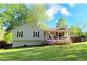 Charming ranch-style home featuring a cozy front porch, lush lawn and colorful flowerbeds at 1643 Cumberland Trce, Acworth, GA 30102