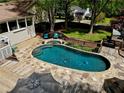 Backyard pool and patio with wooden decking, stone accents, and lush landscaping at 1643 Cumberland Trce, Acworth, GA 30102