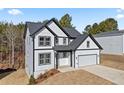 Two-story home featuring white siding, black trim, well-manicured lawn, and an attached garage at 3205 Tackett Rd, Douglasville, GA 30135