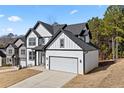 Stylish new construction home boasts white siding, contrasting black trim, and a two-car garage at 3205 Tackett Rd, Douglasville, GA 30135