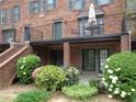 A brick townhouse with a balcony, lush greenery, and manicured landscaping at 3091 Colonial Way # B4, Atlanta, GA 30341