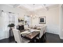 The dining room features hardwood floors, large windows, and elegant decor for comfortable Gathering dining at 6540 Muirfield Pt, Fairburn, GA 30213