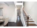 Open-concept hallway with hardwood floors and staircase, connecting to the dining room and other living areas at 6540 Muirfield Pt, Fairburn, GA 30213