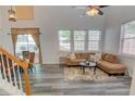Bright living room featuring high ceilings, a ceiling fan, a dining table, and large windows with charming curtains at 102 Manley Ct, Woodstock, GA 30188