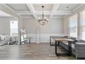 Elegant dining room featuring coffered ceilings, hardwood floors, and modern lighting fixtures at 1052 Bodega Loop, Locust Grove, GA 30248